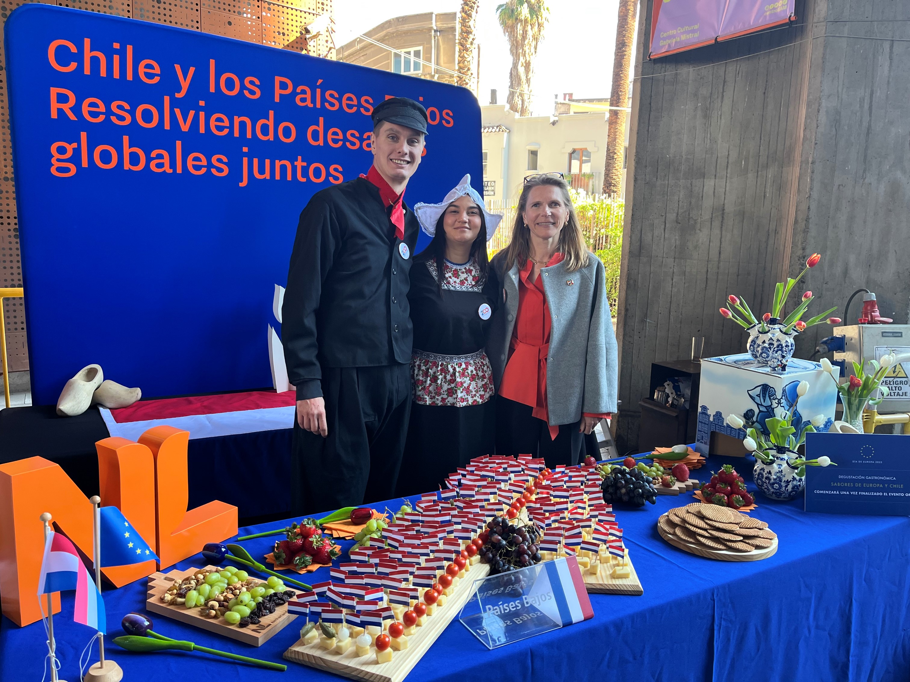 Embajadora con dos personas en traje tradicional