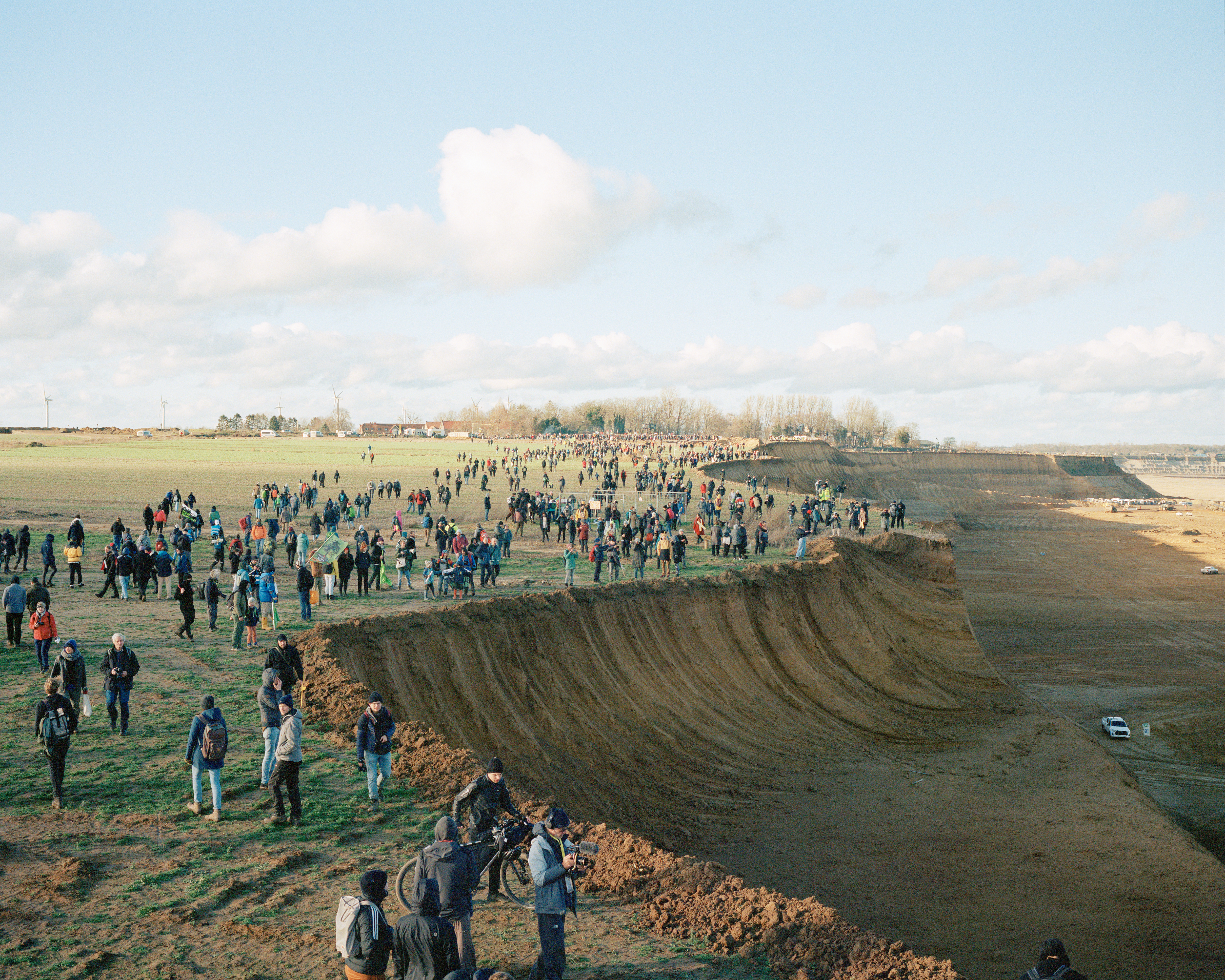 Demonstrators walk along the advancing edge of the Garzweiler II open-cast coal mine near Lützerath, Germany, on the last weekend they could legally enter the village. 8 January 2023.