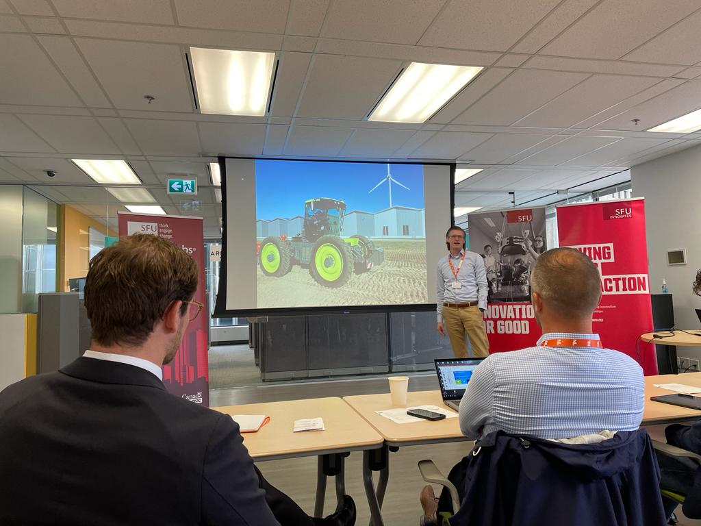 Mission participants listen to a presentation on hydrogen-fueled farming equipment.